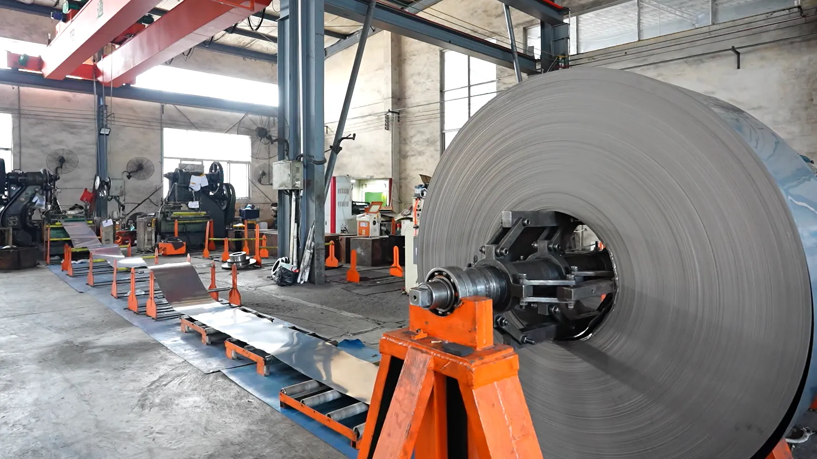 Stainless steel coil loaded on the decoiler at the Potobelo factory, the raw material every cookware grade starts as
